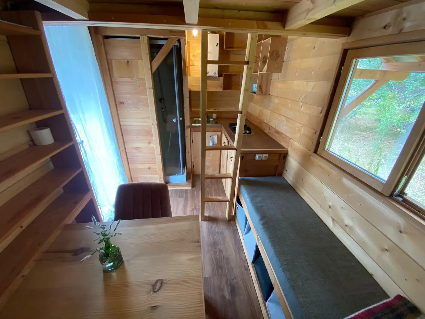 Intérieur de la Tiny House : banquette, échelle et mezzanine